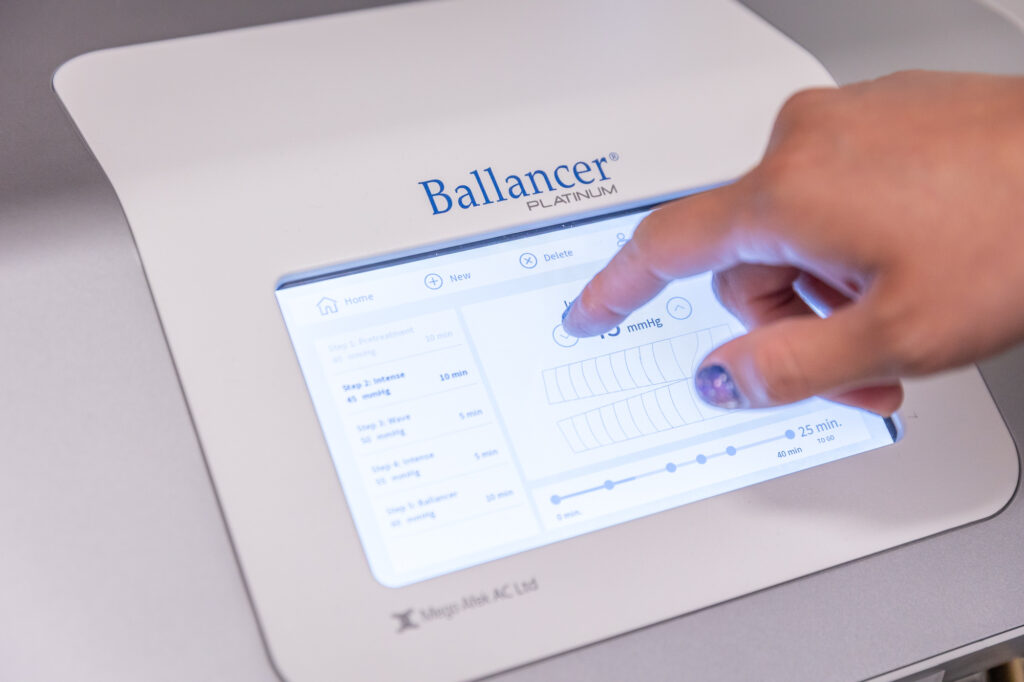 A provider adjusts the treatment settings of the Ballancer Pro suit for lymphatic drainage massage near Prosper, TX.